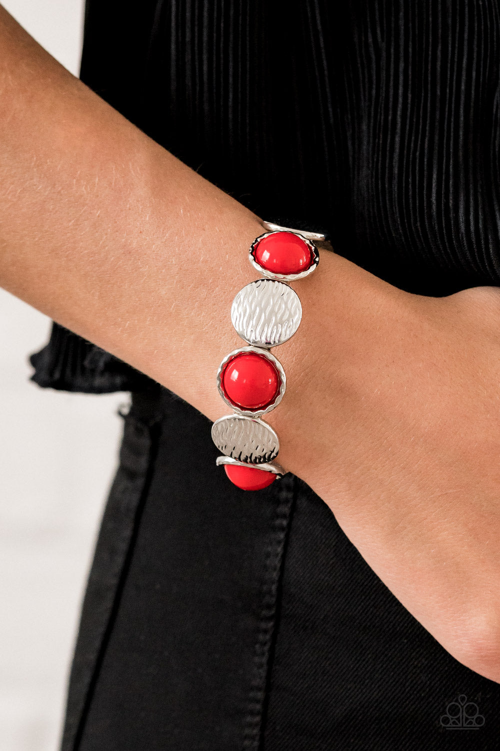 Item #P9WH-RDXX-149SQ Embossed in wavy textures, shiny silver discs and bubbly red beaded frames are threaded along a stretchy band around the wrist, creating a colorful statement piece. Sold as one individual.
