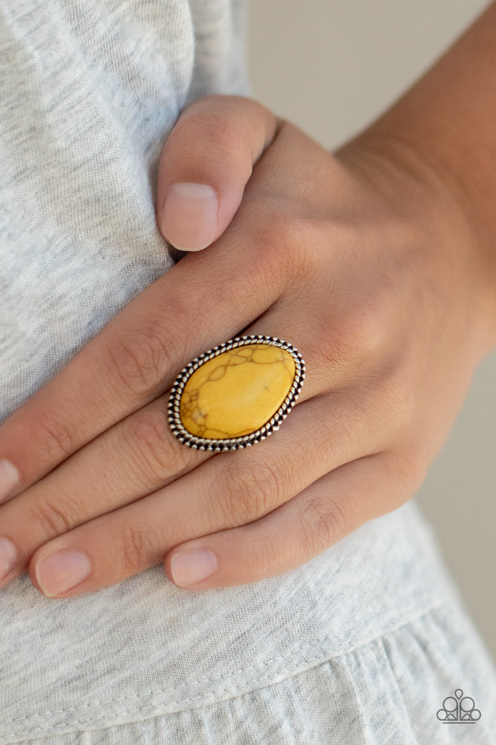Item #P4SE-YWXX-080XX A smooth yellow stone is pressed into a studded silver frame with asymmetrical borders. Features a stretchy band for a flexible fit. Sold as one individual ring.