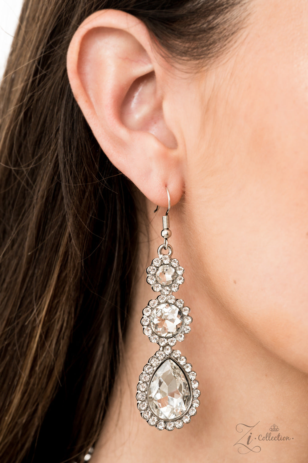 tem #Z916 Encrusted in dainty white rhinestone frames, columns of glassy white gem studded frames increase in size as they drip below the collar. Varying in size and number, white rhinestone encrusted teardrop gems link together as they trickle down the chest , creating a plunging fringe for a ,mesmerizing finish. Features an adjustable clasp closure. Sold as one individual necklace. Includes one pair of matching earrings.