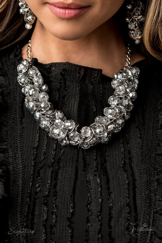 Item #Z2006 A brazen collection of metallic dipped crystal-like beads and delicately bent silver discs boldly cluster into a fearless fringe below the collar. The exaggerated display of jam-packed sparkle takes glitter to a whole new level with its unapologetic attitude. Features an adjustable clasp closure.   Named after 2020 Rock the Runway winner, Haydee, F.  Sold as one individual necklace. Includes one pair of matching earrings.  The Haydee  New Kit
